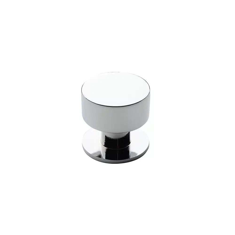 A Taymor Industries round cabinet knob made from zinc die-cast, with a smooth, reflective silver finish and flat top, is displayed against a plain white background.