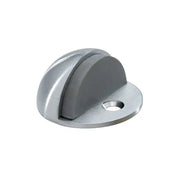 A Taymor Industries silver zinc die-cast dome door stop with a flat base, rubber bumper, and single screw floor mounting hole, isolated on white background.