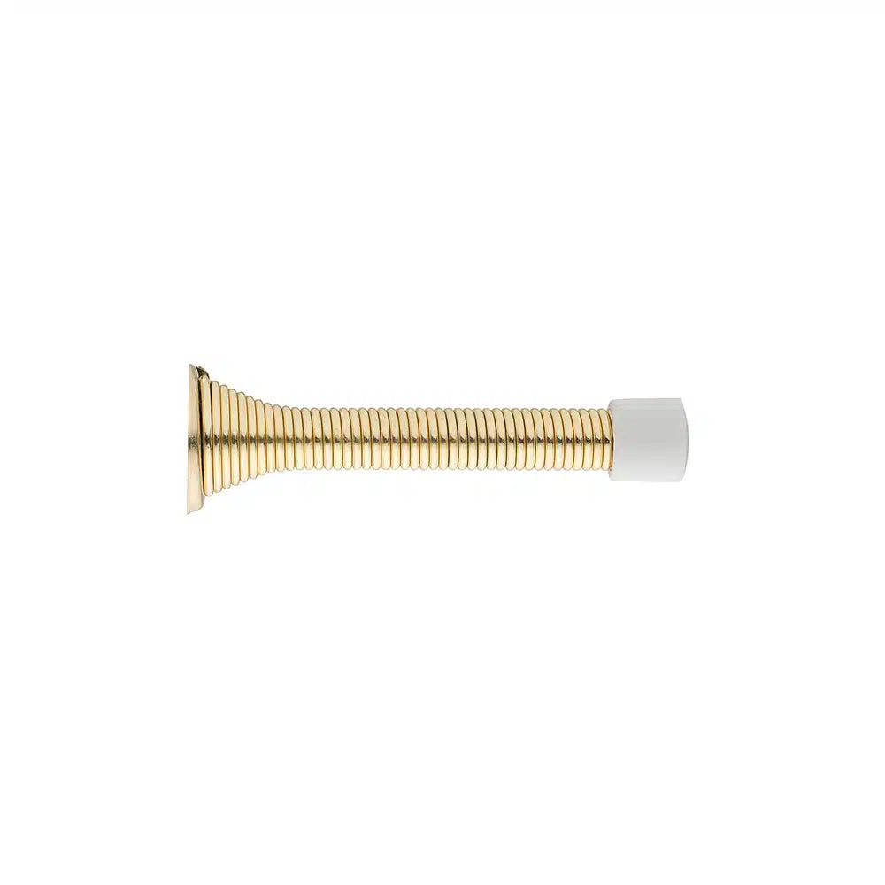 A gold-colored, coiled steel spring doorstop by Taymor Industries, featuring a metal base and white rubber tip, displayed horizontally on a plain white background.