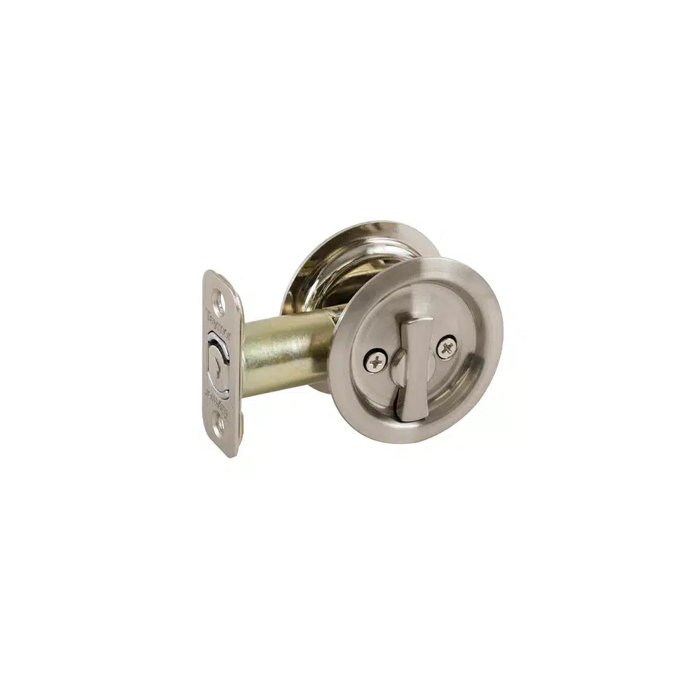 The Taymor Industries satin nickel round pocket door lock features a turn latch, metal mounting plate, and radius corner latch for easy installation, shown on a short section of door edge.