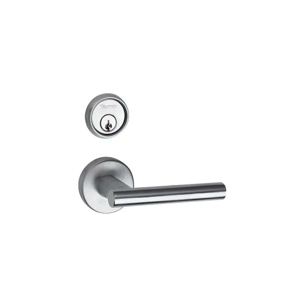 A modern cylindrical silver door handle by Taymor Industries, paired with a matching round fire door lock featuring a 6-pin keyway above it, both displayed on a white background.