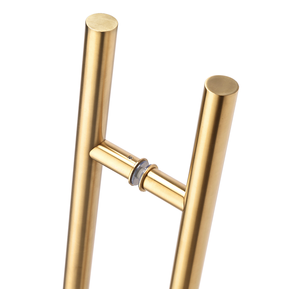 Close-up of Prima Decorative Hardware's modern PVD gold door handle, featuring two vertical cylindrical bars connected by a horizontal bar and a central circular mount. The pull handle boasts a minimal and sleek design.