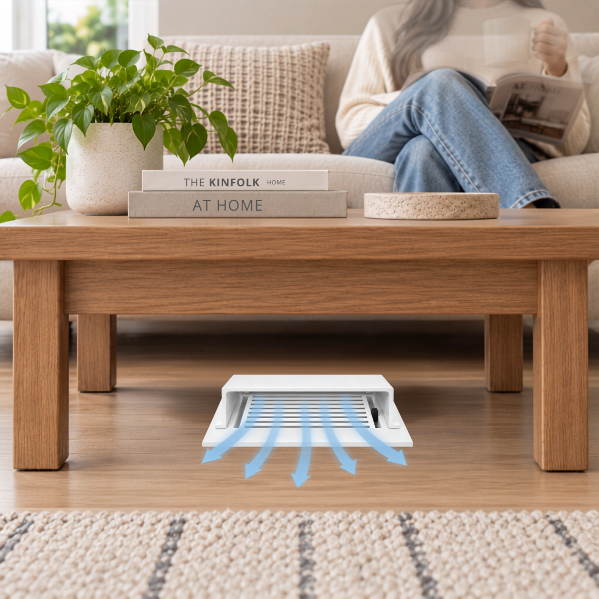 A white deflector installed on a wooden floor beneath a wooden coffee table in a modern living room.
