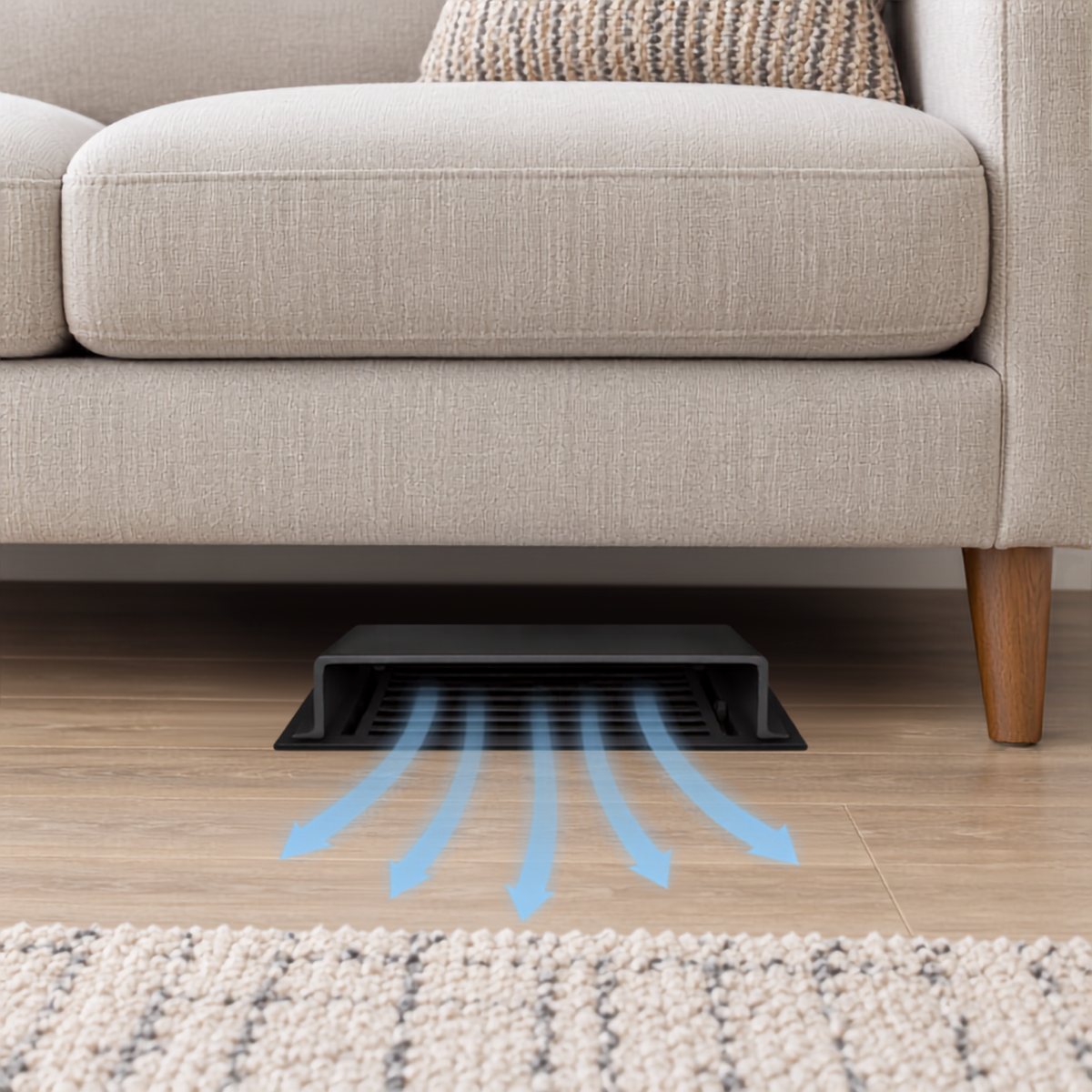 A black deflector installed under a beige sofa on a wood floor.