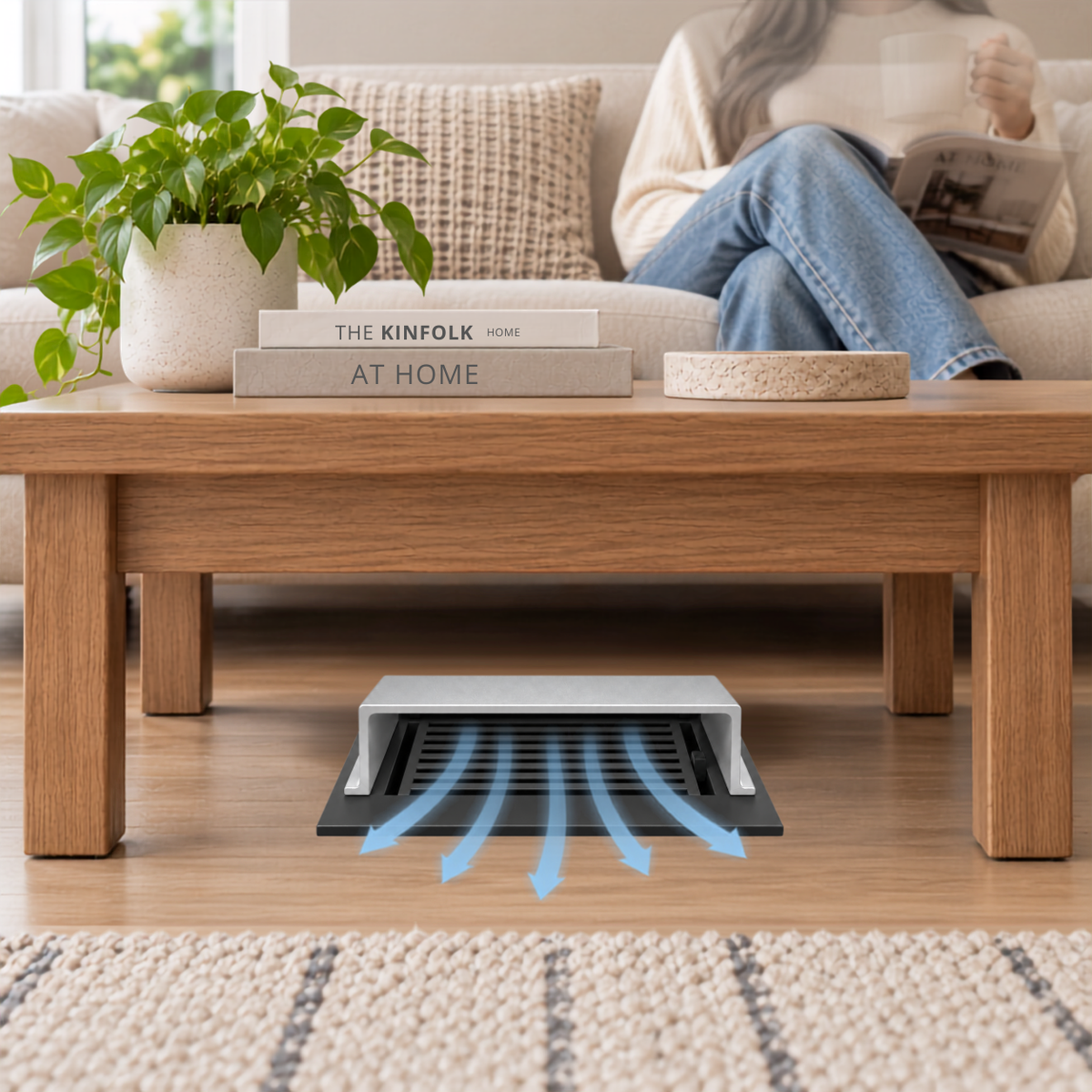 A silver deflector installed on a wooden floor beneath a wooden coffee table in a modern living room.
