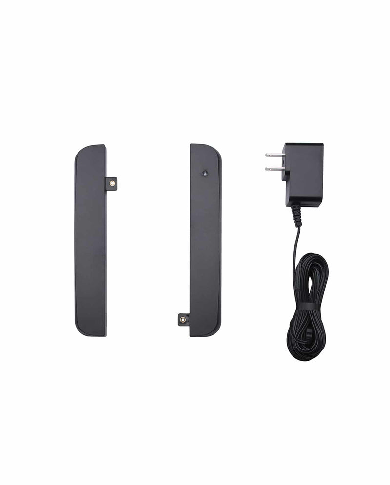 Two black rectangular electronic devices are shown side by side, with a black power adapter and coiled cable placed to the right, all on a white background.