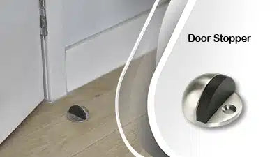 A metallic and black rubber door stopper is mounted on a wooden floor near the bottom of a white door to prevent it from hitting the wall. The words Door Stopper appear next to a close-up of the stopper.