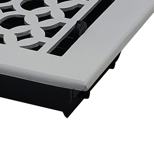 A close-up angled view of the Prima Decorative Hardware rectangular Cast Aluminum Floor Register in white, featuring a decorative geometric pattern.