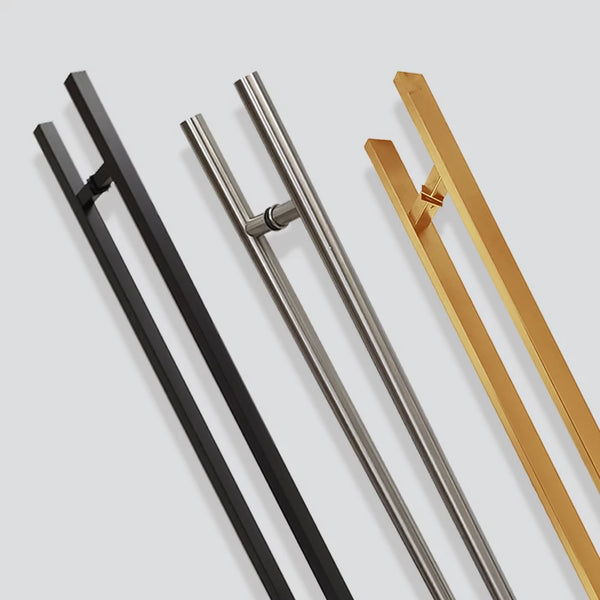 Four modern door handles in black, silver, and gold finishes are displayed vertically against a light grey background. Each handle features a sleek, minimalist design with parallel bars.